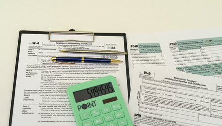 top view of tax forms on tablet on office desk with calculator and pen. The concept of working with...