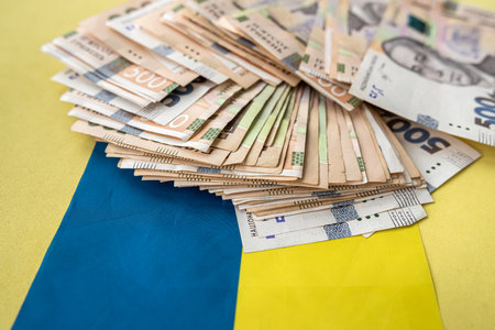 Ukrainian hryvnia lying on national blue yellow flag of Ukraine. Uahの写真素材