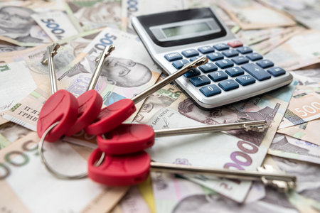 calculator house keys lying on ukraine papre money, uah. finance or shopping conceptの写真素材
