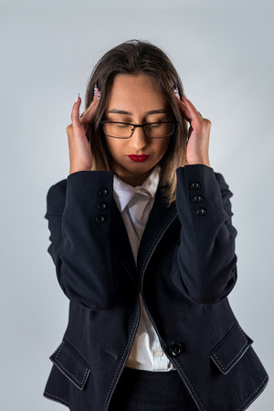 Young beautiful woman wearing stylish clothes over isolated background suffering from headache and despair. Hands on head. headache. migraine.の写真素材