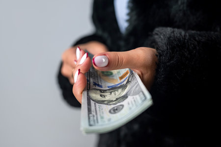 large sum of dollars close up in the beautiful young hands of a woman who has become rich. business and wealth concept. money in handの写真素材