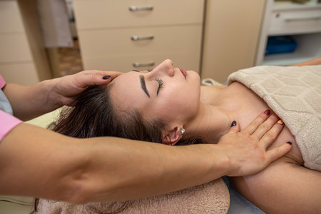 beautiful young girl with dark hair doing a head massage in a massage parlor. Head massage conceptの写真素材