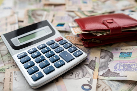 financial concept uah ukraine money with calculator and purse on desk. investment, currency backgroundの写真素材