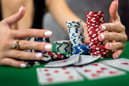 A beautiful young woman is successfully gambling in a casino at a table with cards chips and alcohol...