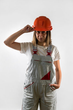 Photo of happy cute smiling good mood female construction worker isolated on white background. Handyman with crossed arms. construction workの写真素材