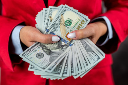 large amount of money in a purse holding a beautiful woman with her feminine hands in front of her. woman boss successful ladyの写真素材