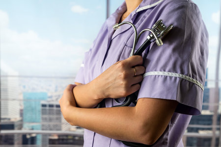 Portrait of a female doctor in a uniform with a stethoscope in her hands on the background of a hospital corridor. medicine. health care stethoscope in handsの写真素材