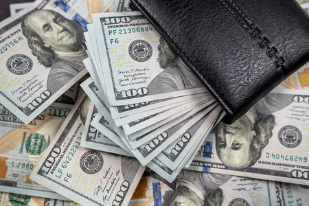 many dollars put in black wallet isolated on black background. Wealth. Abundance. luxury.