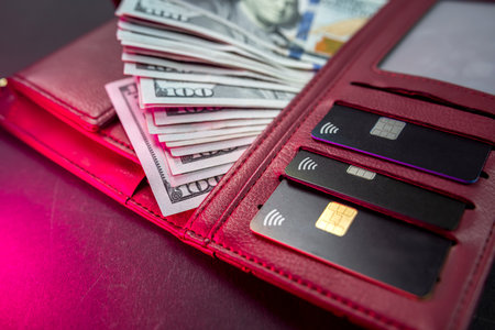 dark wallet with american dollar bills and credit cards isolated on plain background. focus on money. wealth.の写真素材