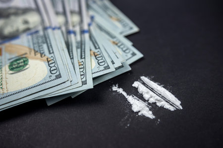 Cocaine or heroin divided into paths on isolated on black background. illegal ways of using drugs