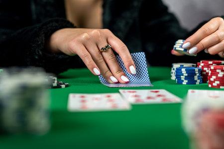 young woman is holding gambling chips and casino cards at the table in a beautiful dress. excitement...