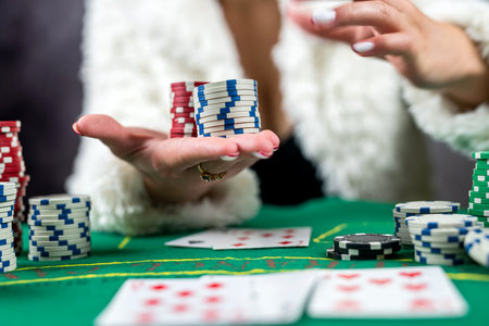 beautiful woman in an evening black dress plays poker in a casino for high stakes. Takes a bet on all chipsの写真素材