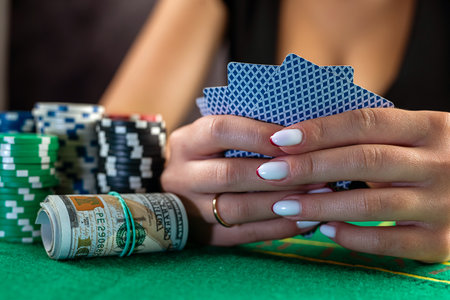 beautiful woman with poker cards is playing low in poker. gambling in the casino. woman in casinoの写真素材