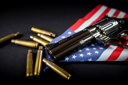 black revolver and ammunition on the folded united states flag is against the constitution of the united states. Violence. banning the sale of illegal weapons.の写真素材