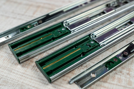 Furniture rails or parts for metal boxes are placed on white wood. The concept of referrals on the...