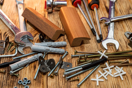 Screws and dowels for hanging objects shown on isolated wood background. repair concept