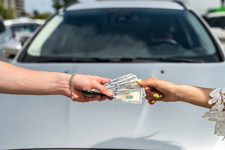 success deal to buy car, man gives dollar salesman, purchase vehicleの写真素材