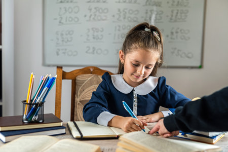 cute little girl is pointed out by the teacher with his hand at her mistakes. school concept. parenting. educationの写真素材