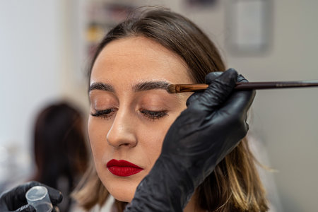 painting and lamination in a beauty salon by a professional craftsman. eyebrow care A master of applying paint with a brush. eyebrow coloring laying procedure. correction.の写真素材