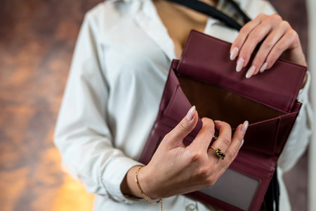 stylish lady in a classic suit holds an open empty purse in tender hands. Empty wallet concept. isolatedの写真素材