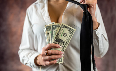 Young beautiful woman holding pile of dollars happy in discreet shirt isolated on plain background. the concept of wealth.の写真素材