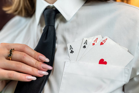 Cropped portrait of a girl where she pulls poker cards out of her white shirt pocket. cunning. poker game isolatedの写真素材