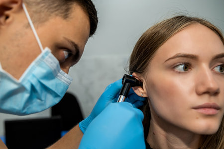 An otolaryngologist examines the auricle. hearing clinic. An ENT doctor with instruments in a mask...