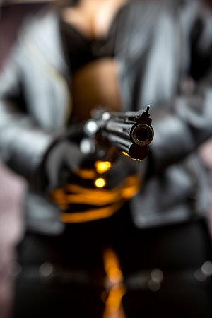 killer in black clothes with black pistol isolated on dark background. danger conceptの写真素材