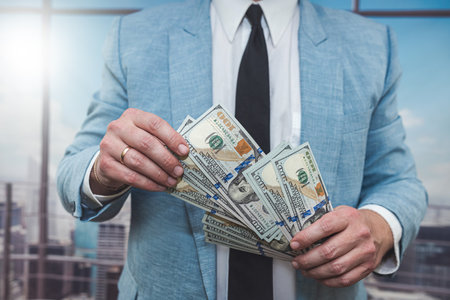 closeup businessman in suit holding one hundred 100 dollar bill. money conceptの写真素材