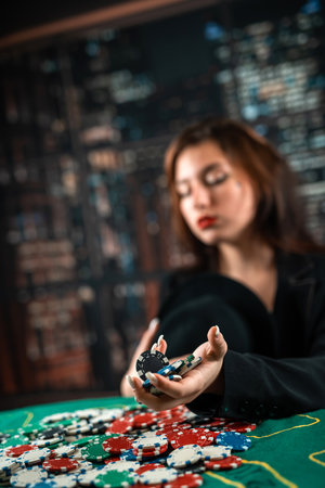 female hand takes poker chips from a pile at a round poker table. risky bets in poker. a woman plays...