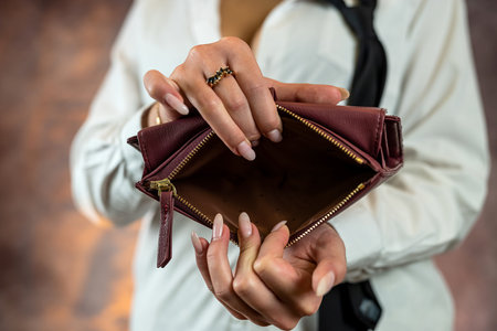 Close-up image of girl's hands with an open empty purse in her hands. An empty wallet is a woman...