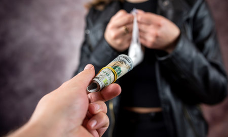 woman addict paying dollar money to drug dealer to buy dose of white powder cocaine. Money exchange for drugs. drug abuse and traffic concept.の写真素材