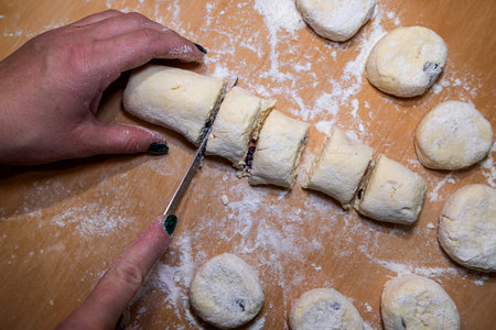 Female hands cut with knife raw sweet dough, the process of making cheesecakes. cooking foodの写真素材