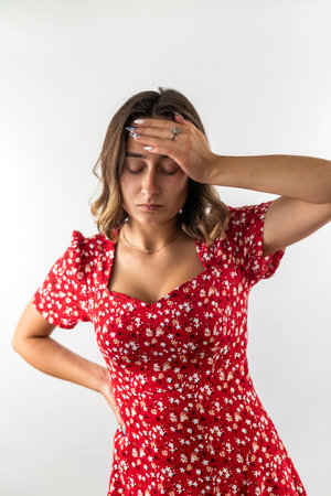 young woman is sick and has a headache isolated on a white background. hands by the head. pain in the waxの写真素材