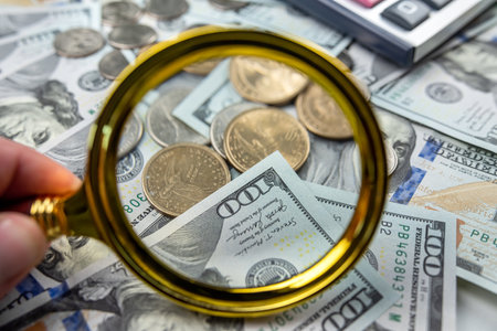 Magnifying glass and calculator on dollars. financial saving concept