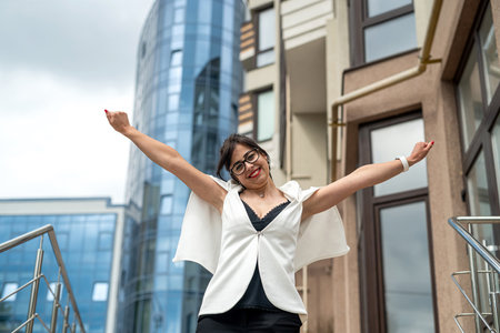 beautiful young stylish talented girl in office clothes posing in front of a building with offices. business concept. portrait of a woman. business womanの写真素材