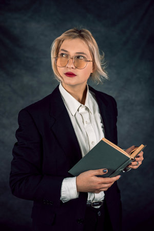 Young and happy beautiful business lady posing in new studio isolated on dark backgrounds. portrait of a woman.の写真素材