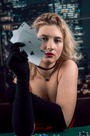 Young woman holding playing cards aces at casino. unemotional face