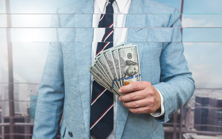 closeup businessman in suit holding one hundred 100 dollar bill. money conceptの写真素材
