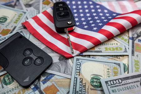 Car's keys on the dollar money and usa flag, finance purchase sale insurance conceptの写真素材