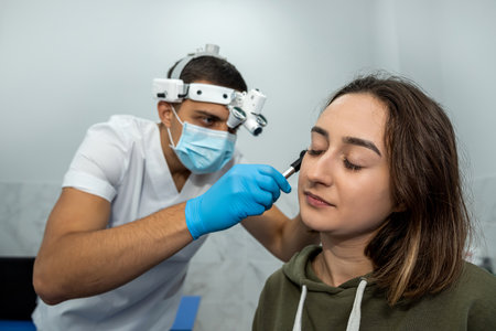 Advanced examination of a woman's ear using an otoscope at a doctor's appointment. Otoscopy. Visit...
