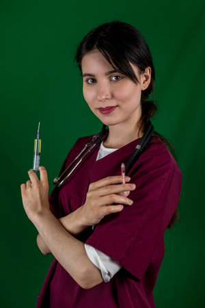 Beautiful female doctor nurse in medical mask and gloves holding syringe with vaccine typical background. Vaccination and healthcare concept.の写真素材
