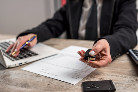 Car dealers gives the car keys to the new owner at showrooms, purcase or rent conceptの写真素材