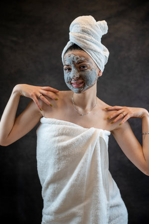 Beautiful girl applying face mask foam bubbles with charcoal oxygen isolated on black background. Skin removing dead, spa treatmentの写真素材