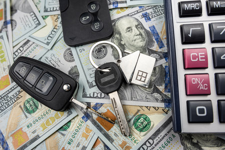 keys of house and car with calculator on us dollar money, Investment in future, purchase or rent conceptの写真素材
