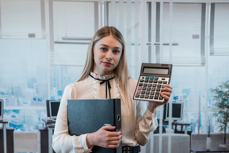 Businesswoman shows calculator at office. Female manager, analysis statistical conceptの写真素材