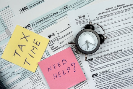 2022 blank us 1040 tax form with clock memo tax time and pen on office desk, paperwork. Accounting...
