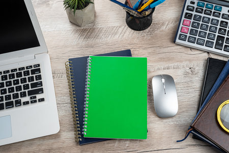 Laptop, blank notepad, pen calculator, reminder flower on office table. Top view. Distance officeの写真素材