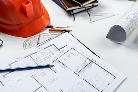 Housing project blueprints with hardhat and tools on office workplace. Construction conceptsの写真素材