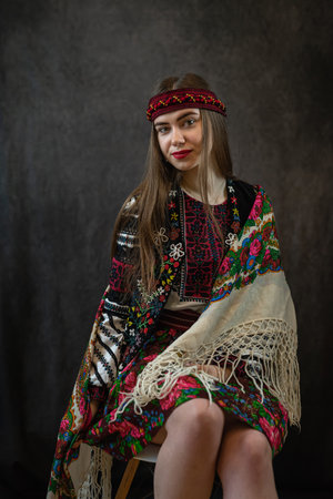 young Ukrainian lady in an embroidered blouse and a shawl poses against a dark background? National clothes, ethnic and folkloreの写真素材